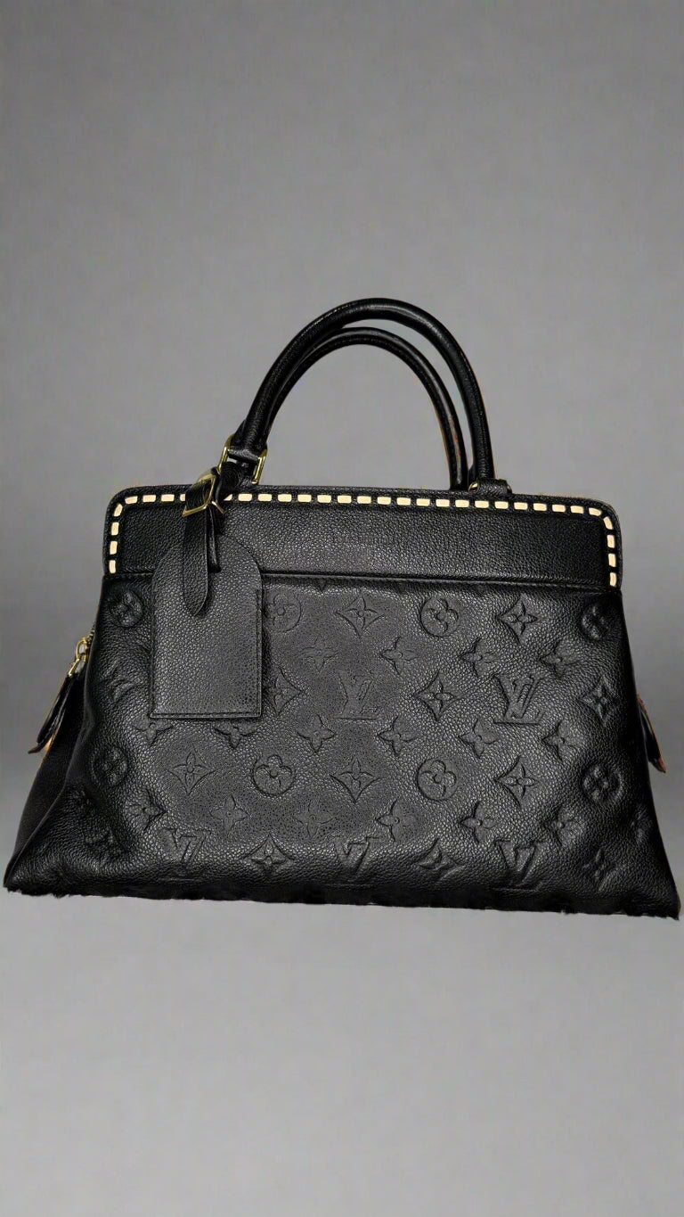 Black embossed handbag on a textured gray background