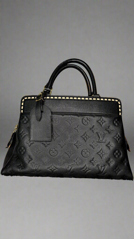 Black embossed handbag on a textured gray background