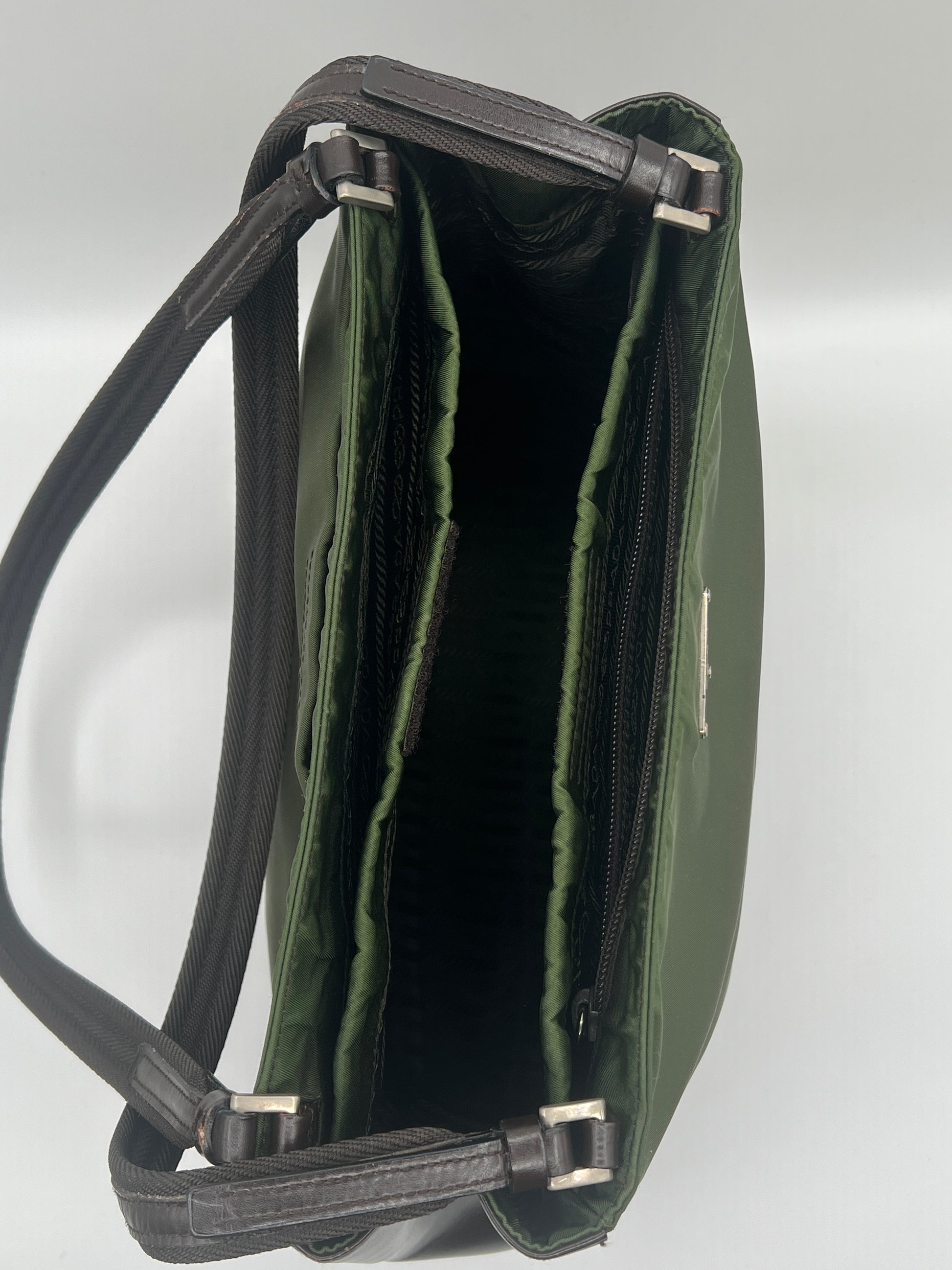 Green leather handbag with a visible brand name on a light gray background