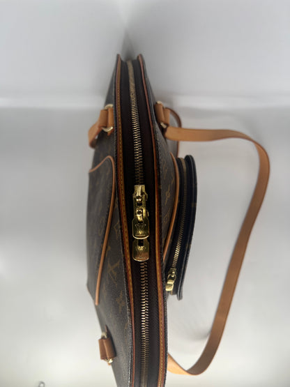 Brown leather handbag with gold zippers on a white background