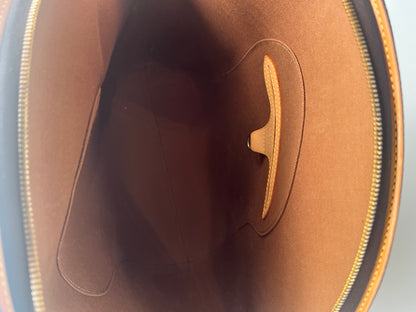 Close-up of a brown leather product with a visible brand logo on a gray background